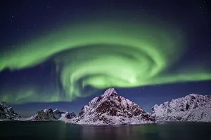 Green northern lights reflected in fjord