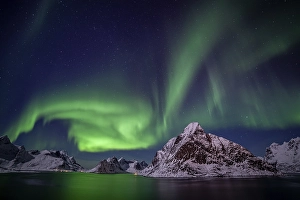 Green northern lights reflected in fjord