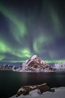 Green northern lights reflected in fjord