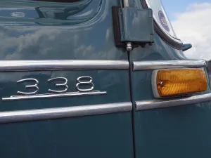 Green vintage car with tail light and the number 338 on the bodywork