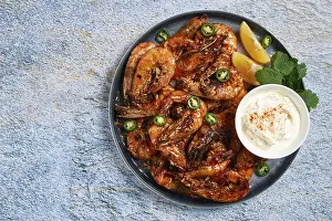 Grilled shrimps served with hot sauce and slices of fresh lemon