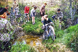 A group of cyclists cross a small river on their bicycles, probably in Kent, England, UK 1956