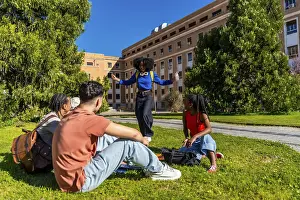 Group of diverse college students sitting and standing on green grass