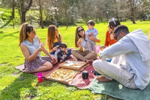 Group of friends and their children having fun at a picnic in a park