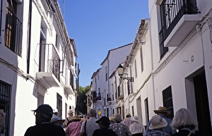 A group on a guided tour through the narrow streets of Ronda, Spain, Europe