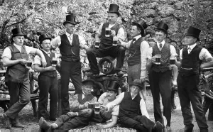 Group of nen wearing top hats drinking beer