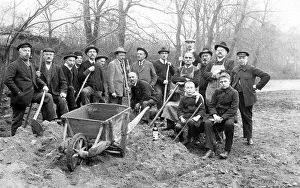 Group picture, construction workers with sand heap and spades