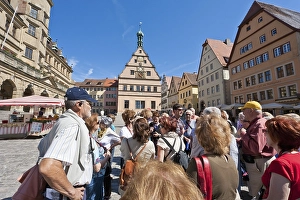 Group of tourists with a tour guide on the market square