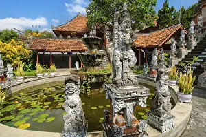 Guardian figures in front of an old well in Brahma Vihara Arama Buddha Banjar Buddhist monastery