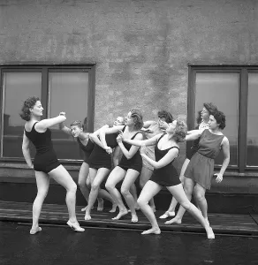 Gymnasts in the 1940s. A group of women gymnasts are training together on a top of a building