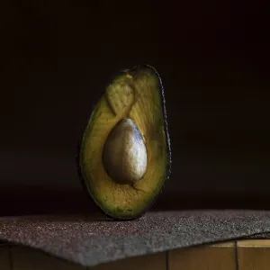 A half avocado is placed on a rough