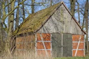 A half-timbered barn stands in a grove