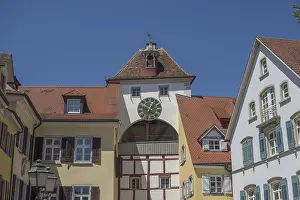 Half-timbered house with clock and church tower in the old town