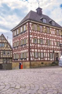 Another half-timbered house on a cobbled street under a blue sky