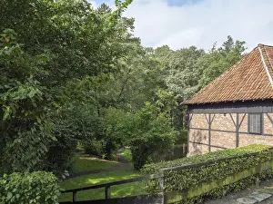 Half-timbered house in the middle of lush nature and forest with well-kept hedge