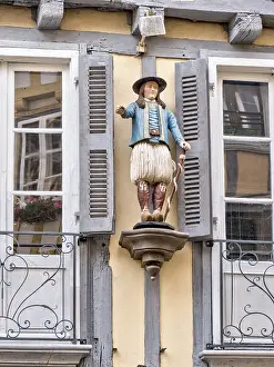 Detail of the half-timbered house with statue of a man in historical traditional costume in the Rue Kereon