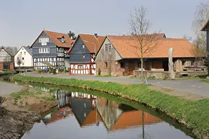 Half-timbered houses being reflected in the water of the Treisbach creek