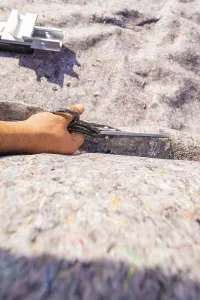Hand holding a tool on a textured surface