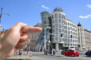 Hand pointing at the famous dancing house in prague