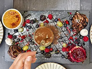 Hand with spoon tasting a dessert