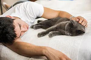 Handsome Young Animal-Lover Man on a Bed