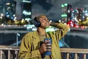 Framed Print : Happy black woman relaxing in a vibrant city at night