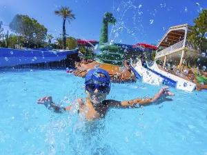 Happy child wearing blue baseball cap and swimming goggles