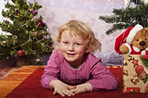 Happy girl, 4, lying on the floor at Christmas