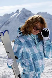 The happy girl in a blue ski suit on a background of mountains Elbrus