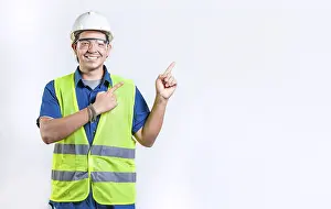 Happy male engineer pointing to side isolated