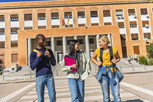 Happy multi-ethnic students at the end of the day walking out university