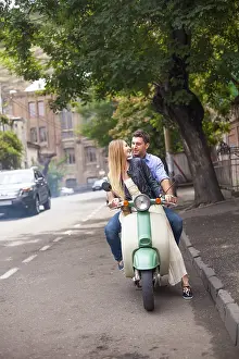 Framed Print : Happy young couple by a vintage scooter on the street