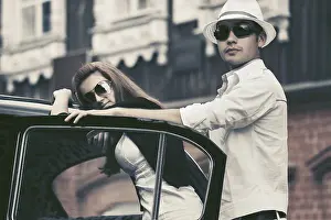 Framed Print : Happy young fashion couple next to vintage car