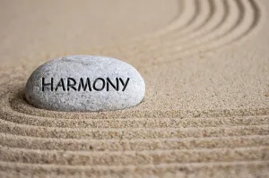 Harmony text engraved on Zen stone on sand