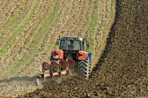 Harvested grain field being turned into a field by Steyr tractor with plough