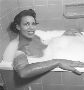 Having a bath 1950. A young smiling woman is having a bath in a bathtub at home