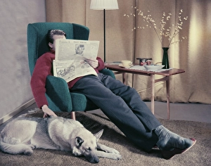 Having a nap in the 1950s. A man has fallen asleep while reading the paper