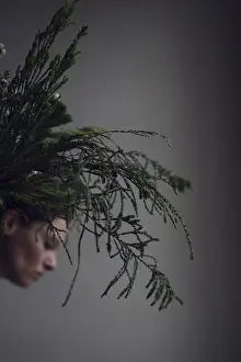 Head of woman behind ostrich with grasses