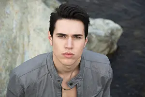 Headshot of attractive young man outdoor looking up at camera