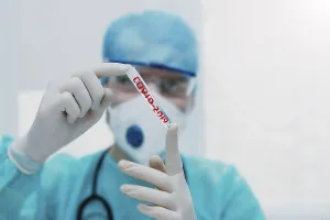 A healthcare worker holding COVID-2019 test tube wearing protective gear