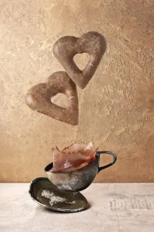 Heart shaped gingerbread cookies flying over coffee cup with splashes