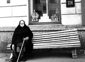 Heavy grandmother sits on the bench