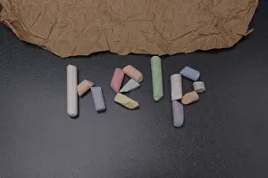 Help word written incoloured chalk on a black chalkboard