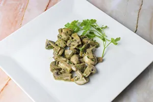Herb-marinated mushrooms with parsley on a square white plate