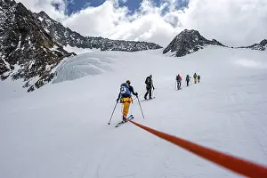 High altitude tour, ski tourers walking on a rope over Alpeiner Ferner glacier