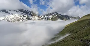 High fog in the valley, mountain peaks above the clouds