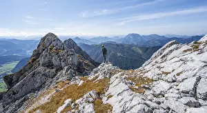 Hiker with climbing helmet, on hiking trail at a ridge