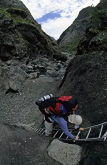 Hiker climbing a ladder at the Riviere des Galets