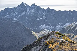 Hiker on a hiking trail in front of the mountains