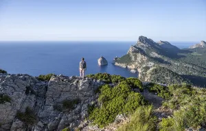 Hiker looking over rocky cliffs and sea